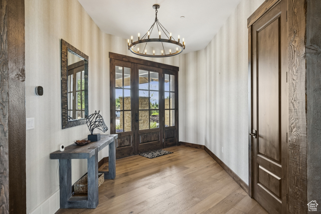Foyer featuring a chandelier, hardwood / wood-style flooring, and baseboards