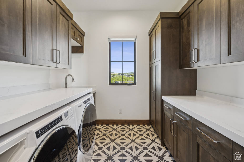 Laundry area featuring cabinet space, independent washer and dryer, and baseboards