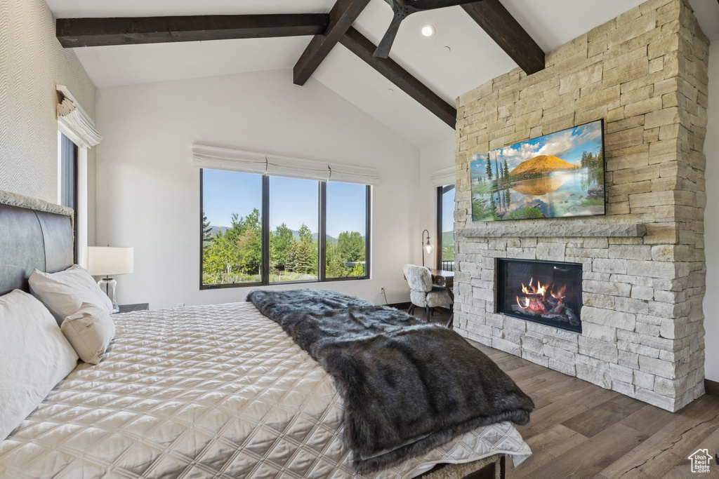 Bedroom featuring wood finished floors and a fireplace
