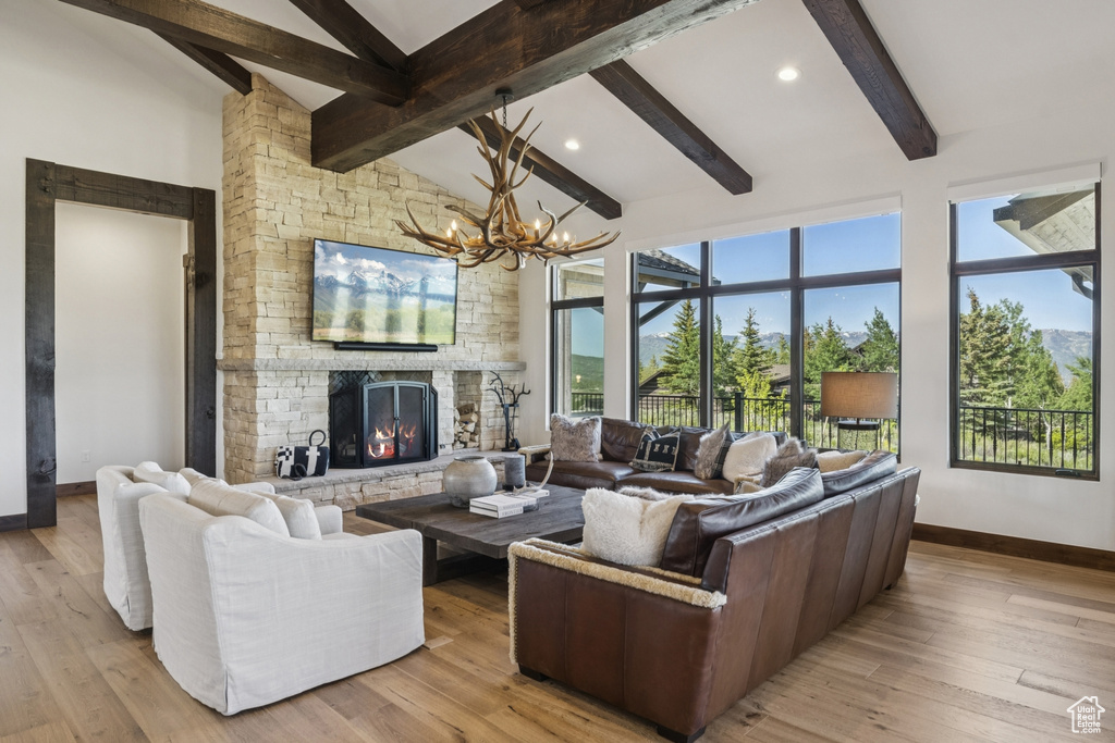 Living area featuring baseboards, a chandelier, light wood-style floors, a fireplace, and recessed lighting