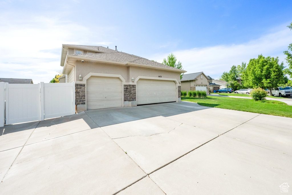 View of property exterior featuring concrete driveway, stone siding, a garage, and stucco siding