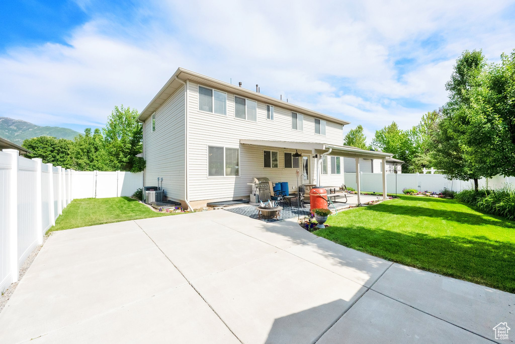 Rear view of house with a patio area and central AC unit
