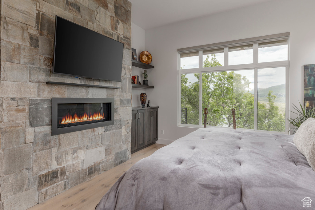 Bedroom with wood finished floors and a fireplace