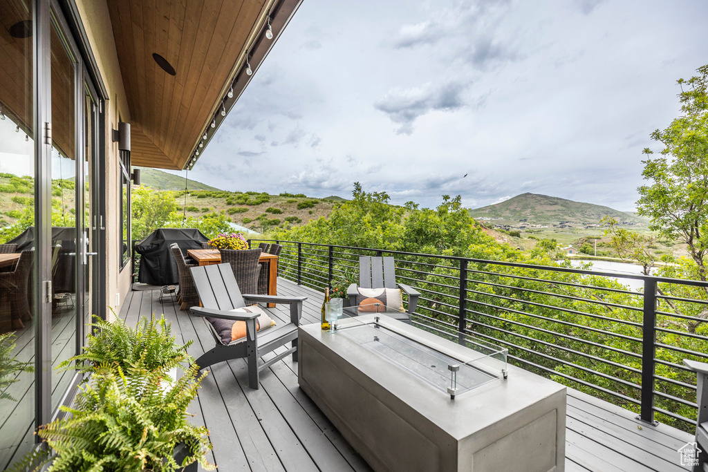 Wooden deck with a mountain view and grilling area