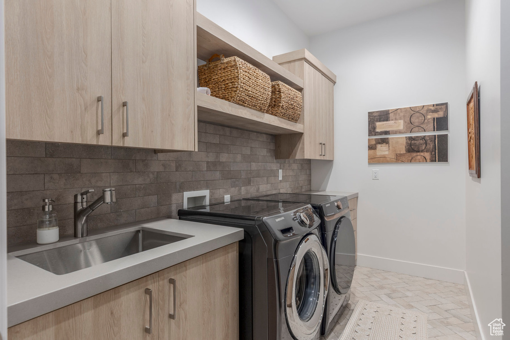 Laundry room featuring cabinet space, separate washer and dryer, and baseboards