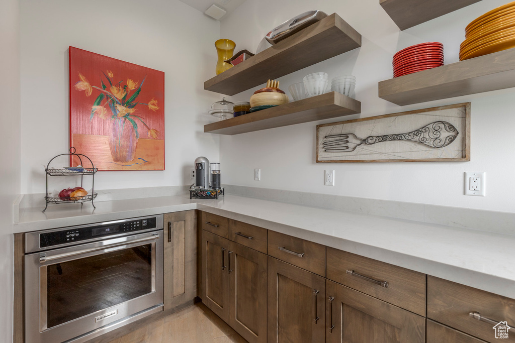 Kitchen featuring oven, open shelves, and light countertops