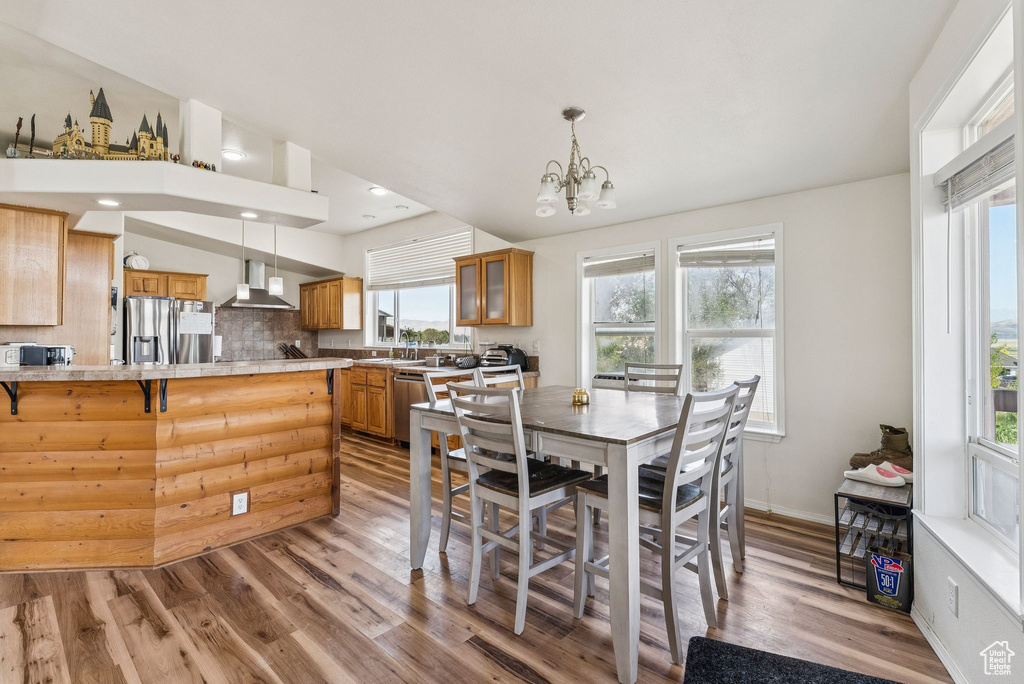 Dining space featuring light wood-style flooring, a chandelier, and baseboards