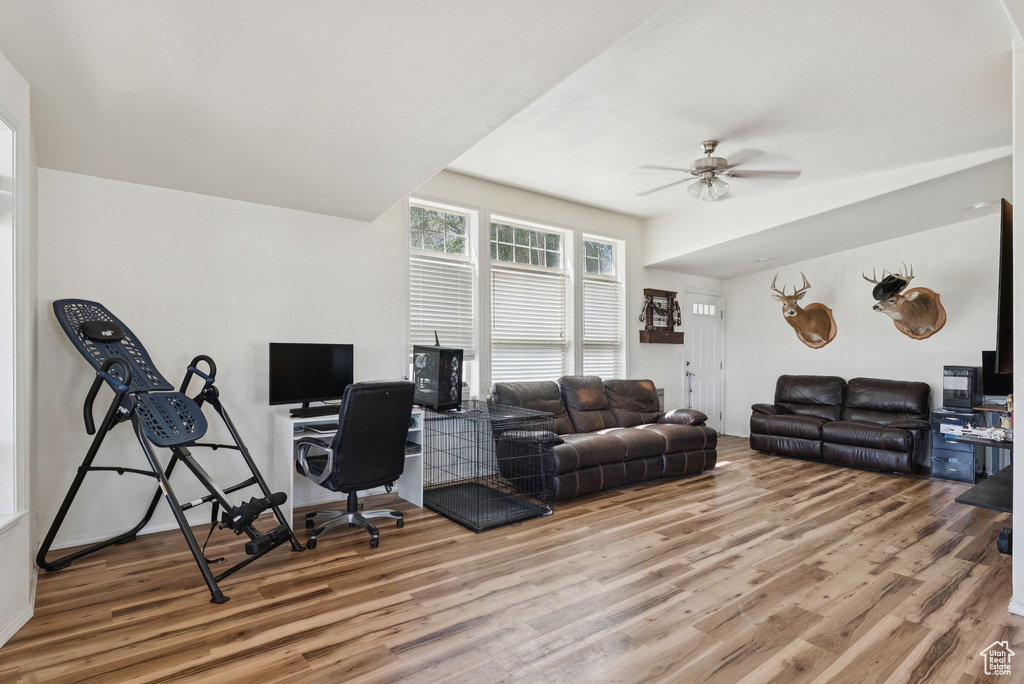 Living room featuring wood finished floors, a ceiling fan, and a desk