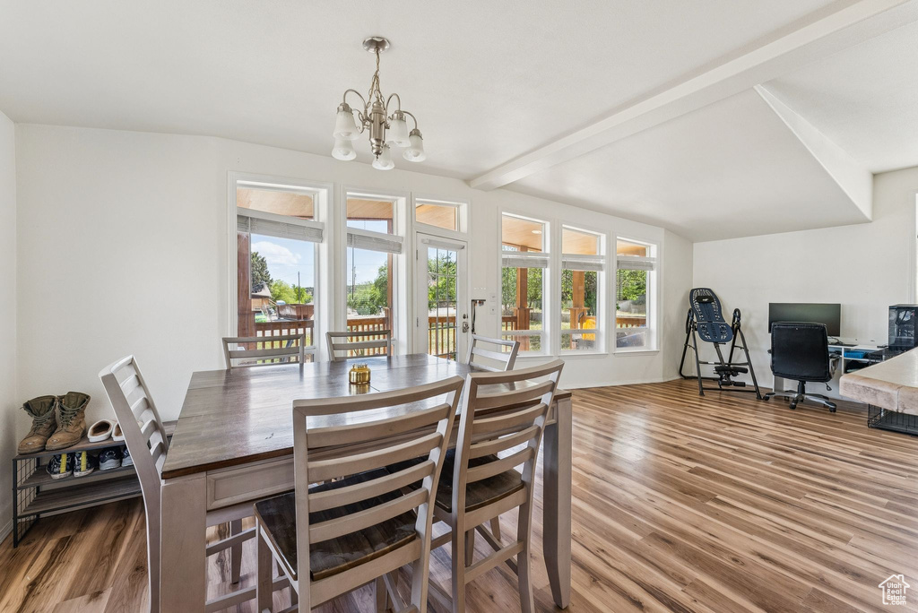 Dining area with a chandelier, wood finished floors, and beam ceiling