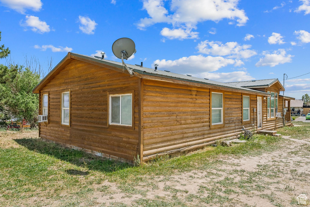 View of property exterior with metal roof and cooling unit