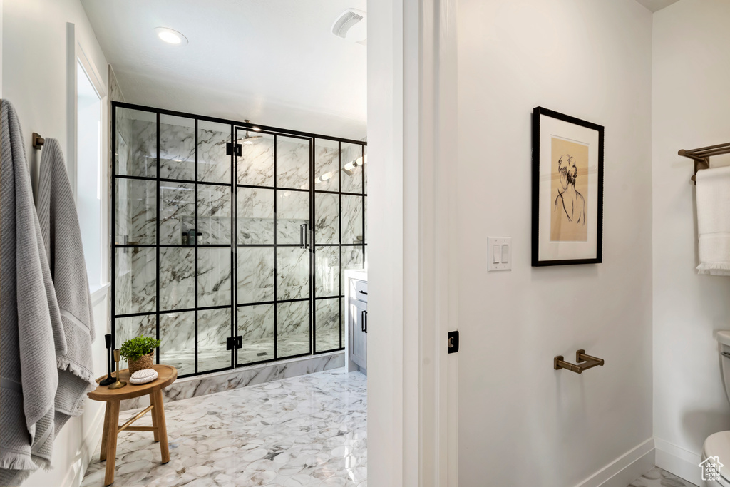 Full bathroom with toilet, a stall shower, marble look tile flooring, baseboards, and recessed lighting