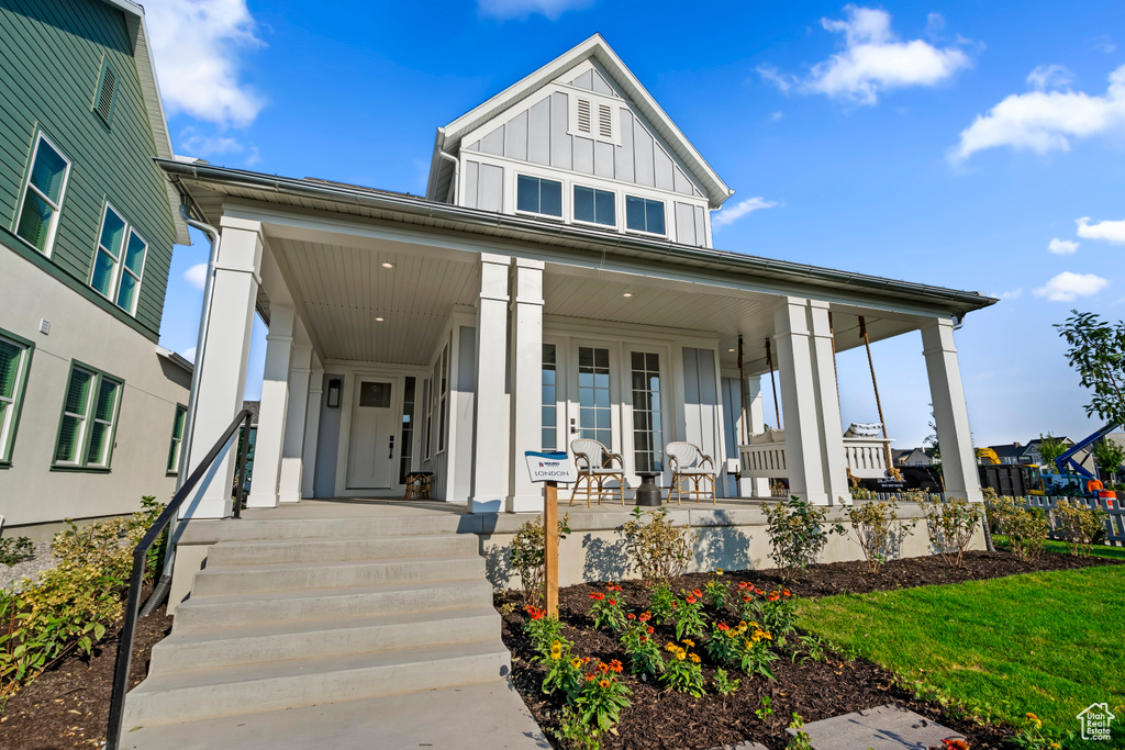 View of front of house with board and batten siding and a porch