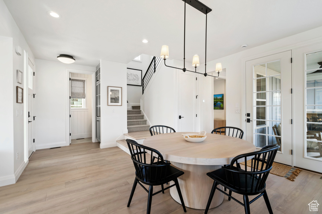 Dining space with stairway, light wood finished floors, baseboards, a chandelier, and recessed lighting