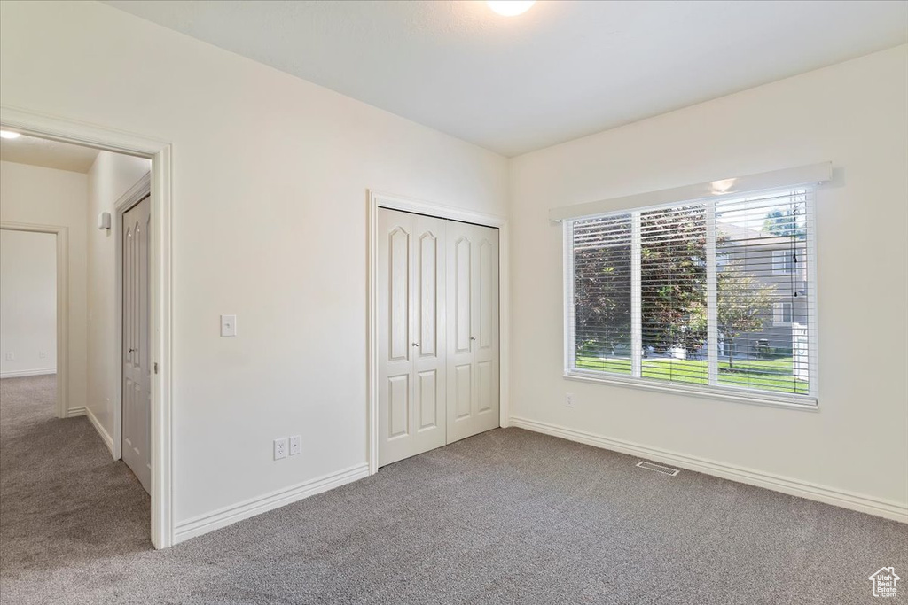 Unfurnished bedroom with carpet flooring, baseboards, and a closet