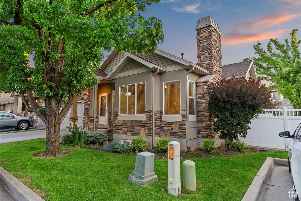 View of front of property with stone siding, stucco siding, and a chimney