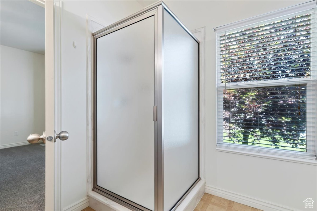 Full bath with a stall shower and baseboards