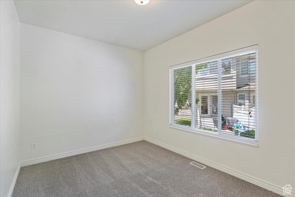 Carpeted empty room featuring baseboards