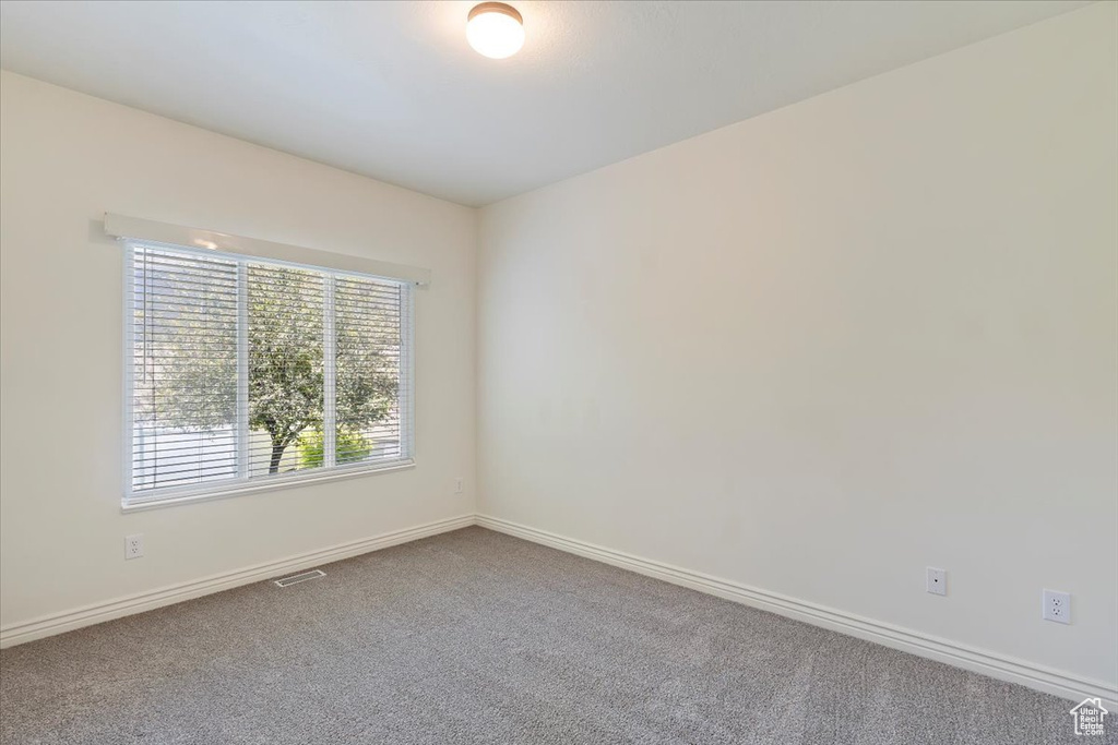 Carpeted spare room with baseboards
