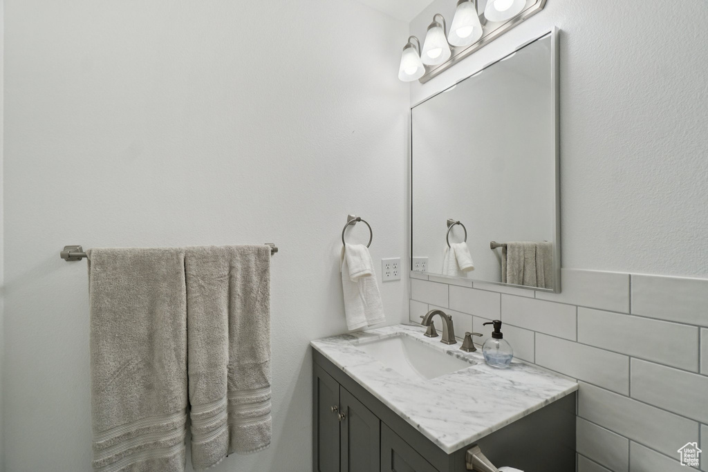 Bathroom featuring vanity and tasteful backsplash