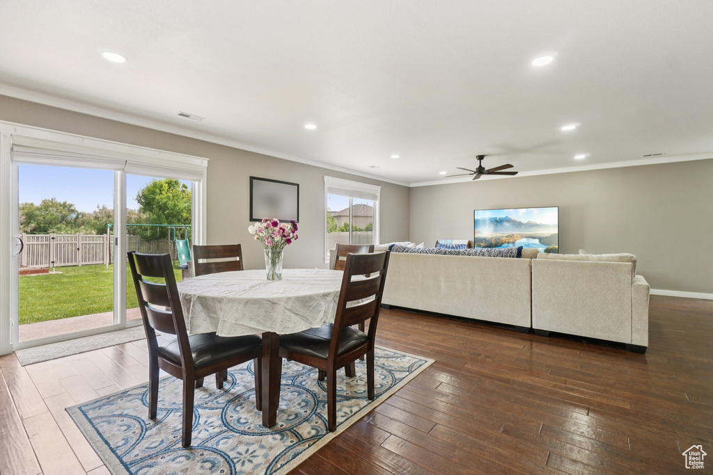 Dining room with crown molding, a ceiling fan, dark wood finished floors, and recessed lighting