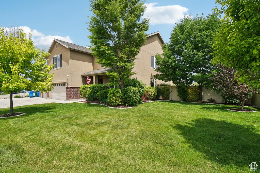 View of home's exterior featuring stucco siding, a garage, concrete driveway, and a lawn