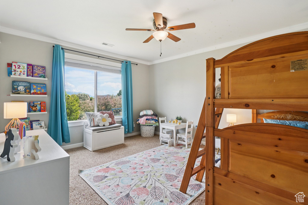 Bedroom featuring light carpet, crown molding, baseboards, and a ceiling fan