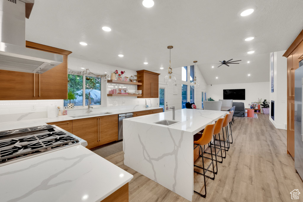 Kitchen with exhaust hood, a sink, dishwasher, backsplash, and recessed lighting
