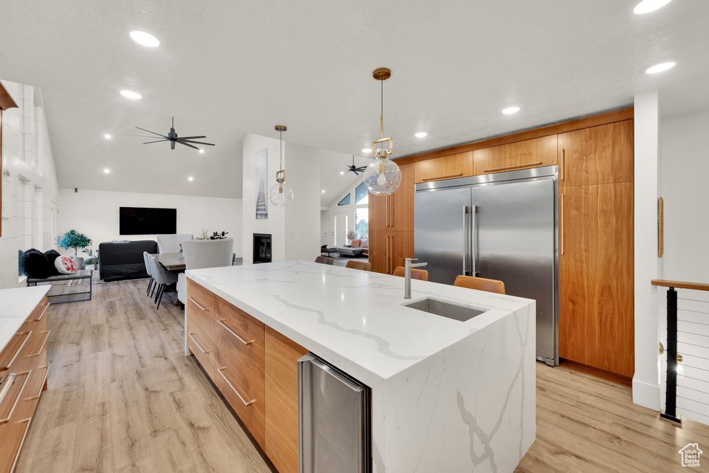 Kitchen with modern cabinets, built in refrigerator, ceiling fan, light wood-type flooring, and recessed lighting