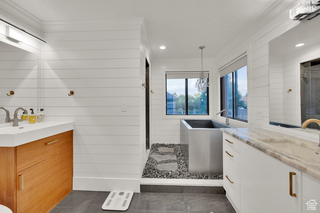Full bathroom with two vanities, ornamental molding, a stall shower, and recessed lighting