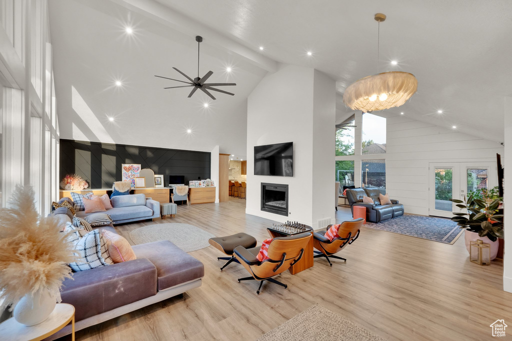 Living area with high vaulted ceiling, a fireplace, light wood-type flooring, recessed lighting, and a ceiling fan