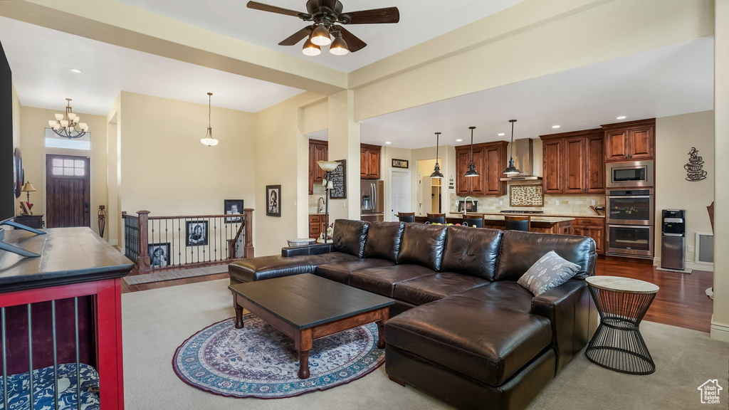 Living area with ceiling fan, recessed lighting, wood finished floors, and a chandelier
