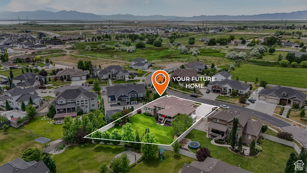 Aerial perspective of suburban area with property boundaries highlighted and a mountain backdrop