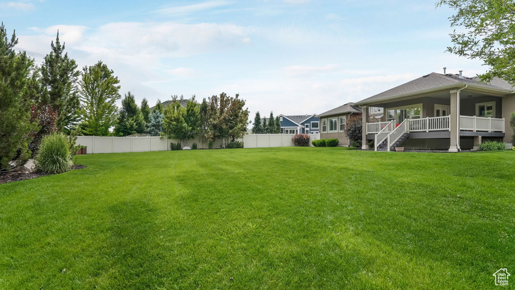 View of yard with a deck and stairs
