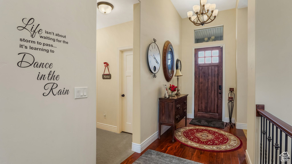 Entrance foyer with a chandelier, wood finished floors, and baseboards