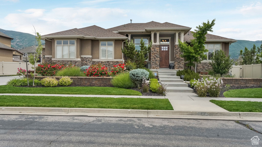 Prairie-style house featuring stone siding, a mountain view, and stucco siding