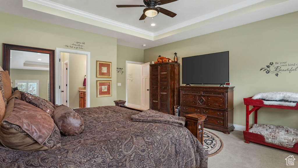 Carpeted bedroom featuring a raised ceiling, ornamental molding, recessed lighting, baseboards, and ensuite bathroom