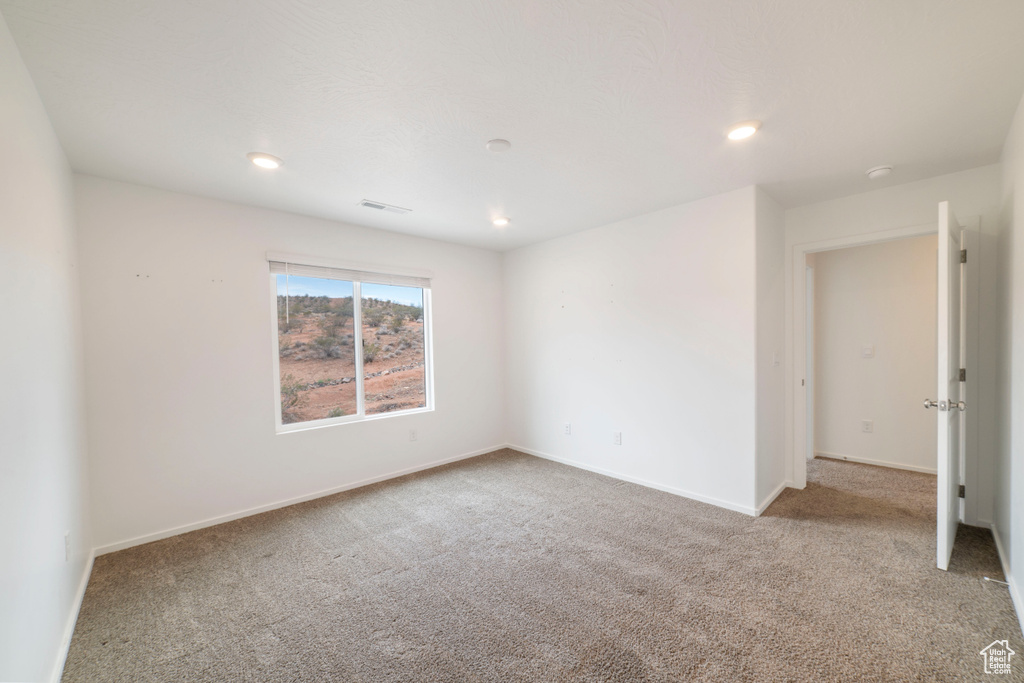 Spare room featuring carpet flooring, recessed lighting, baseboards, and a smoke detector