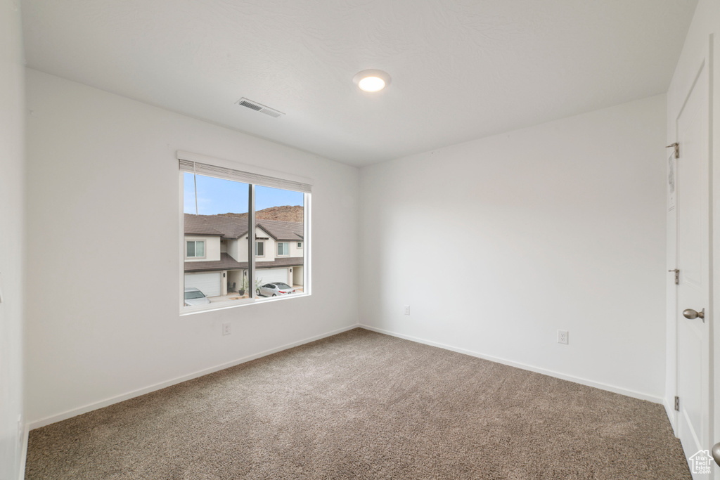 Carpeted empty room with baseboards