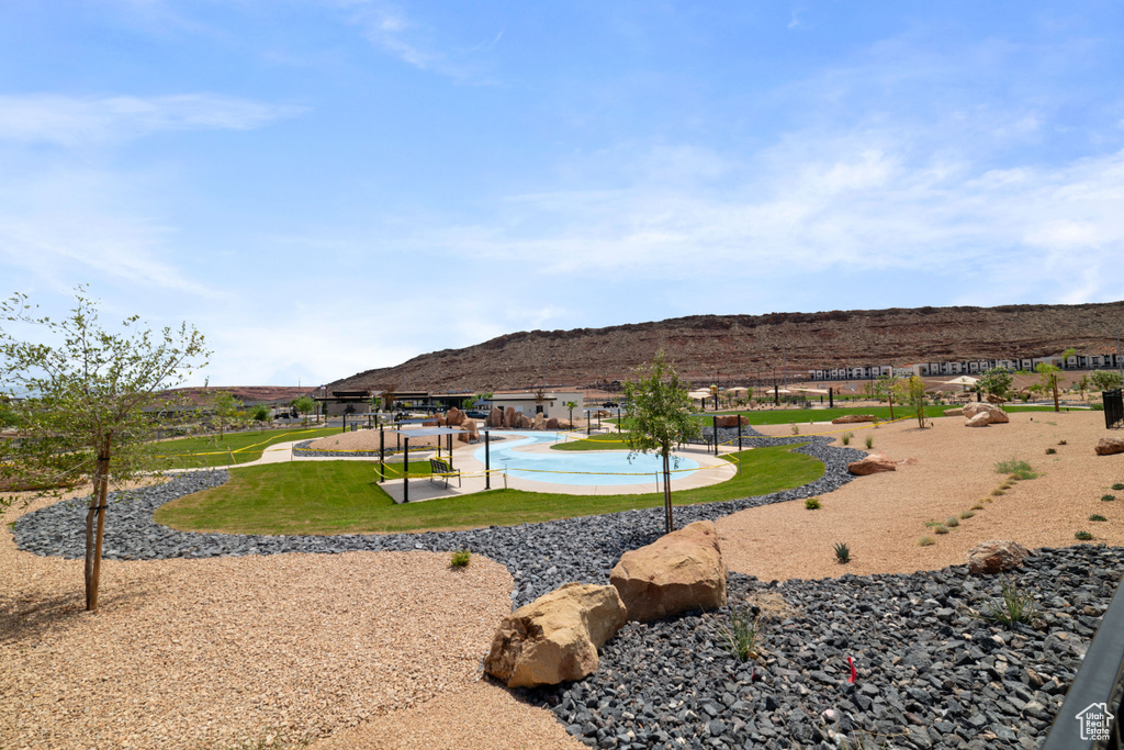 Surrounding community with a mountain view, a lawn, and a pool