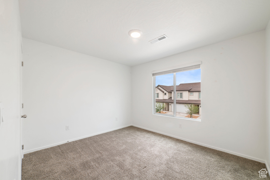 Carpeted spare room with baseboards
