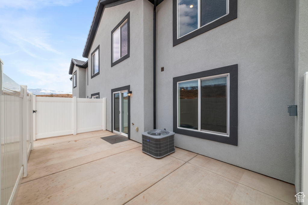 Rear view of house featuring a patio area, stucco siding, and central AC