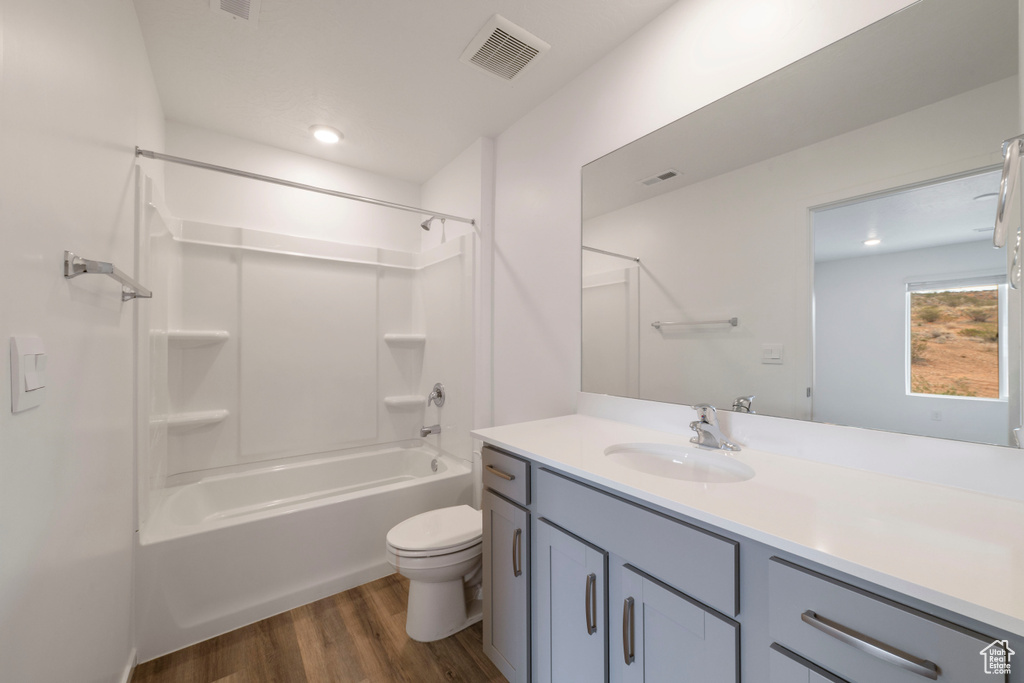 Bathroom featuring wood finished floors, vanity, toilet, bathing tub / shower combination, and recessed lighting