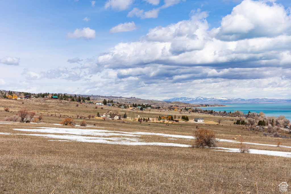 View of mountain backdrop with a nearby body of water and rural landscape
