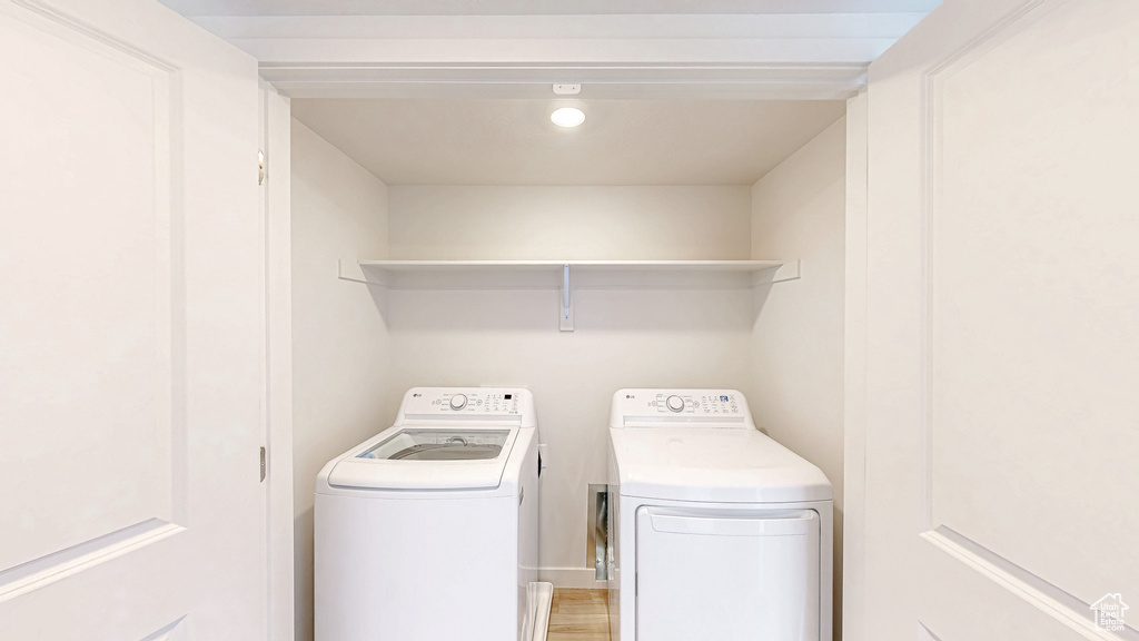Washroom featuring washer and dryer and light wood-style flooring