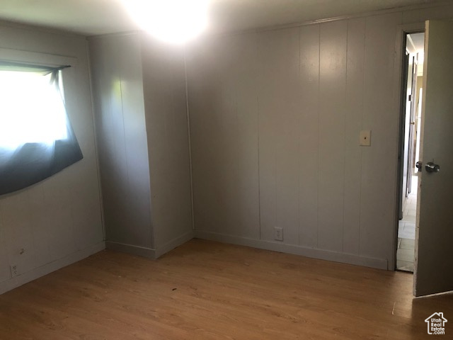 Unfurnished room featuring light wood finished floors and baseboards