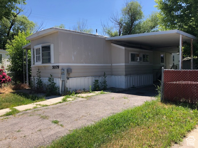 View of front of home with asphalt driveway and an attached carport