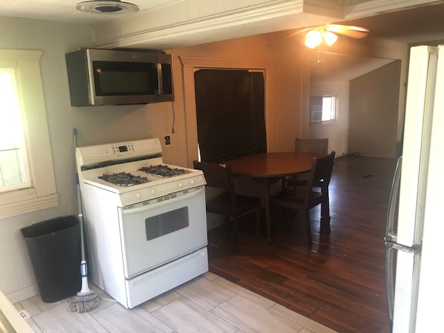Kitchen featuring white appliances, light wood-type flooring, and ceiling fan