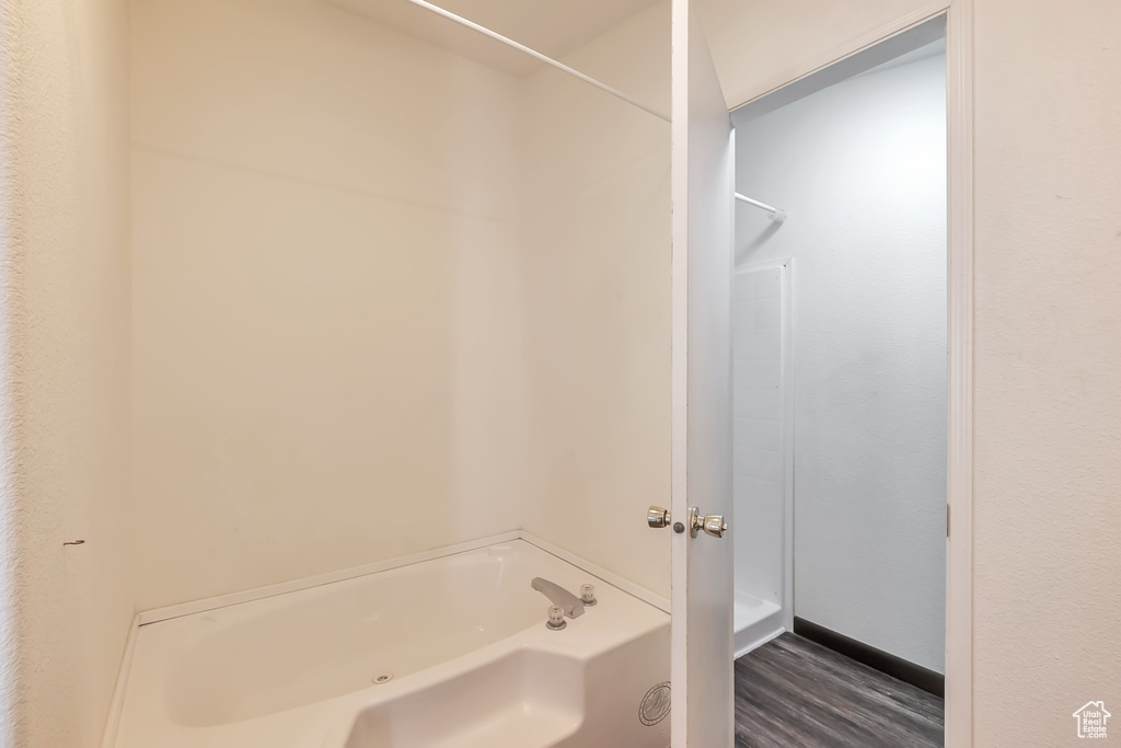 Bathroom with a bath and wood finished floors