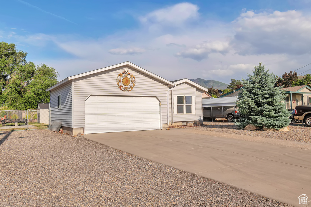 View of front facade featuring driveway and an attached garage