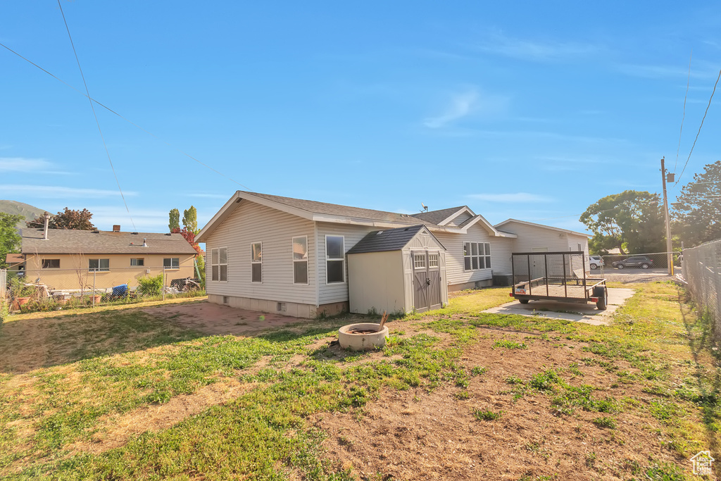 Back of property with a fire pit and crawl space
